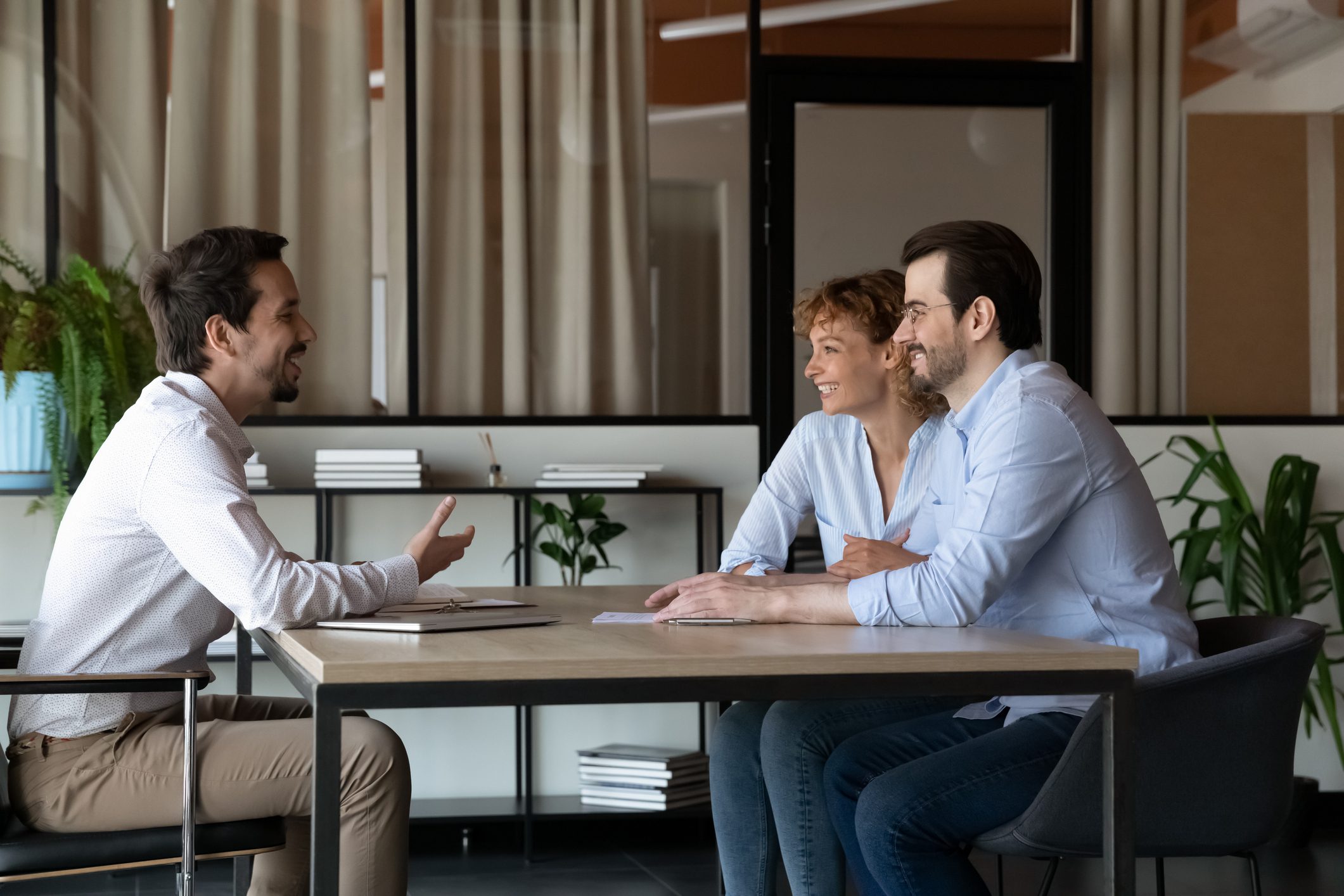 A happy couple meet with their mortgage lender for cross-sell blog.